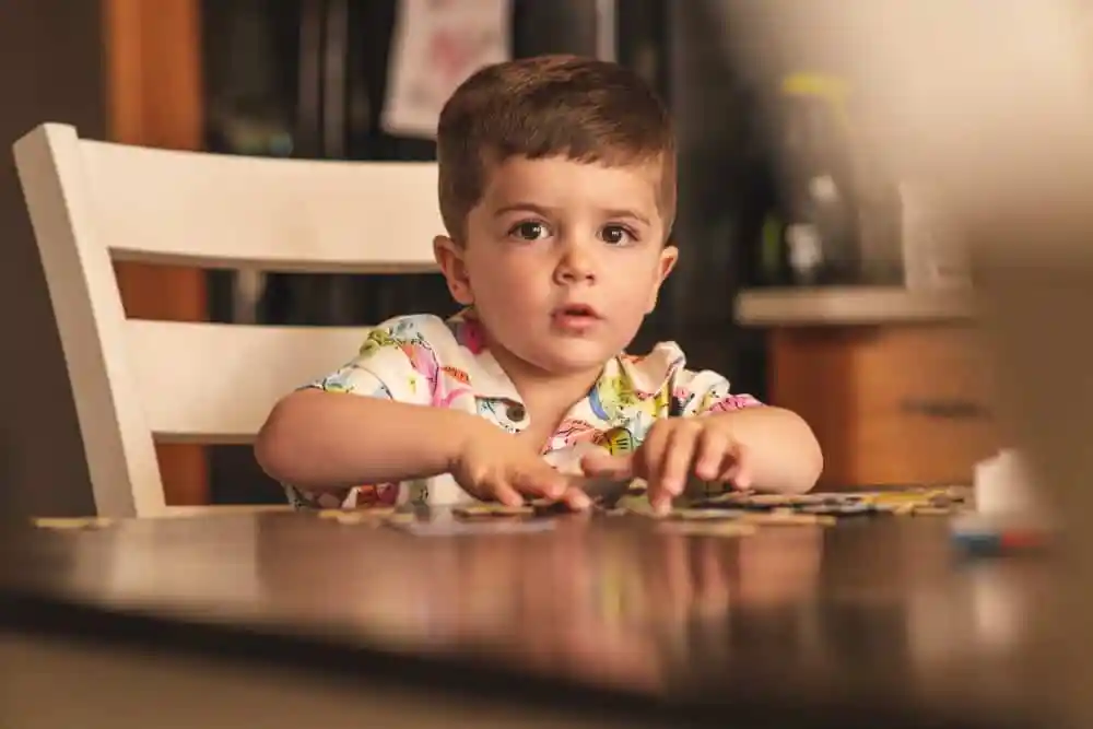 A kid playing jisaw puzzle