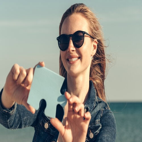 women with sunglasses holding a jigsaw puzzle