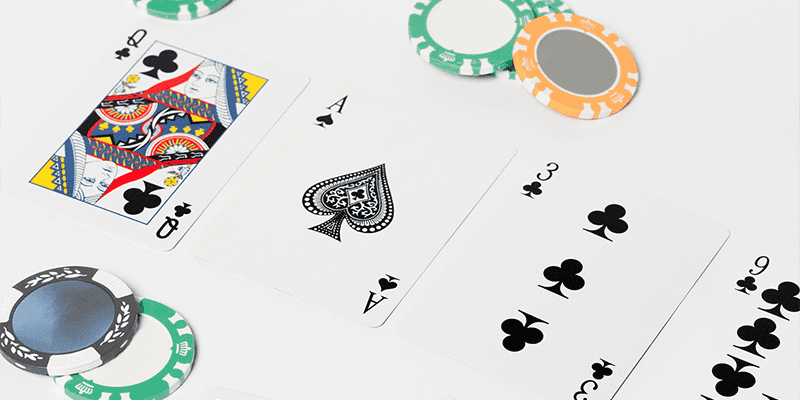 playing cards and poker chips laid on a white surface