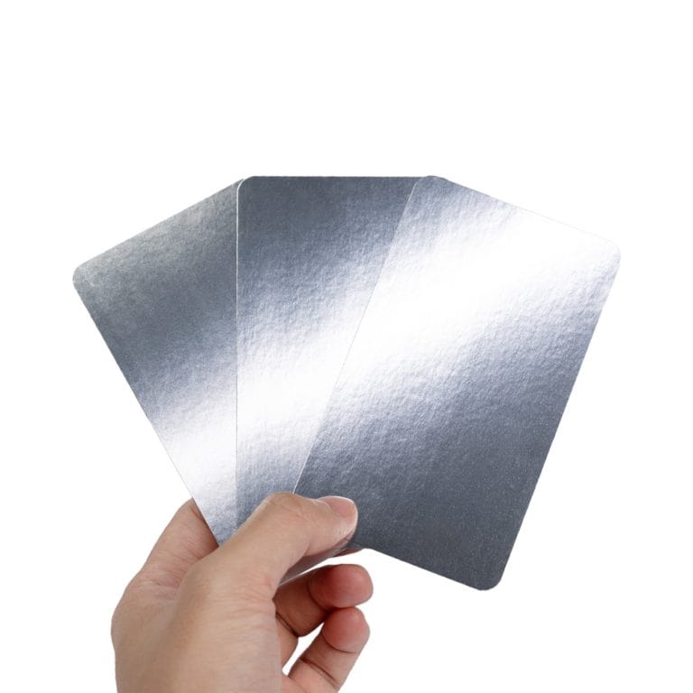 A hand holding 3 cards with silver foil