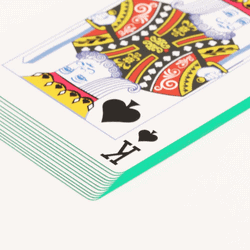 stack of playing cards with greed edges and the king of spades on top