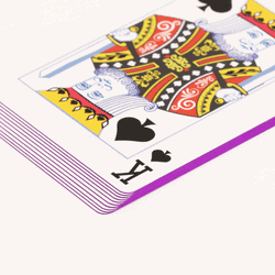 stack of playing cards with purple edges and the king of spades on top