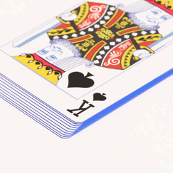 stack of playing cards with blue edges and the king of spades on top