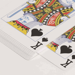 stack of playing cards with silver edges and the king of spades on top