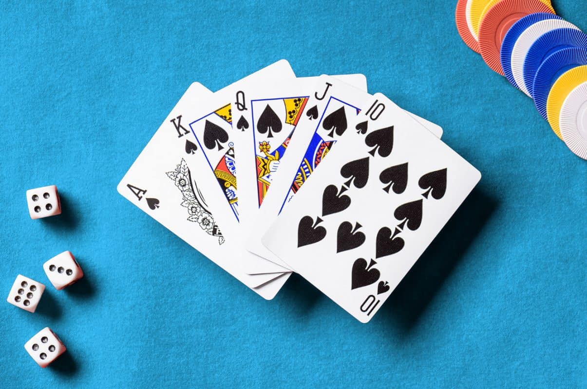 a royal flush playing card hand on a blue surface