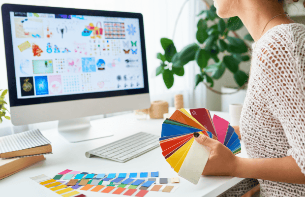 Women holding color cards and working on desktop computer