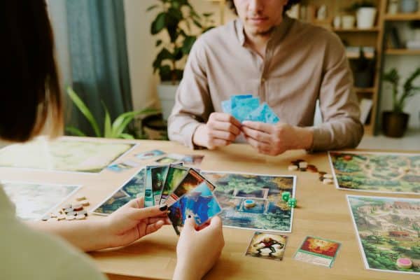 two people playing a card game at a table