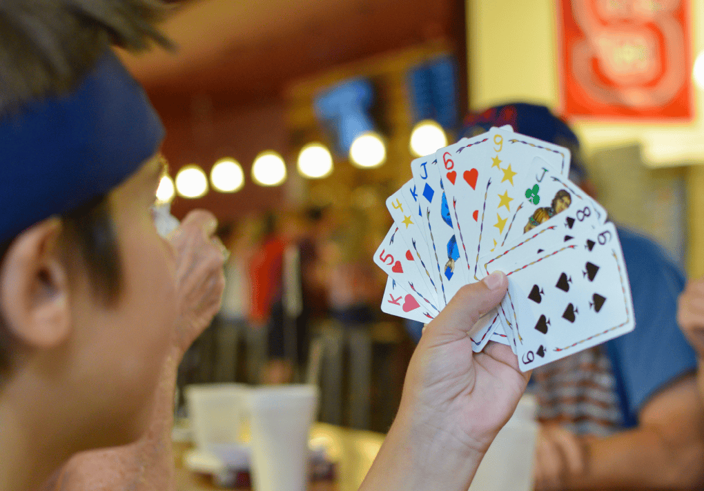 a man holding a fanned out hand of cards