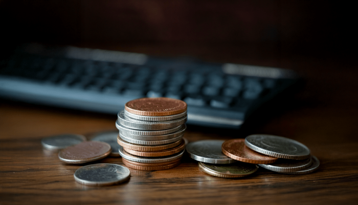 coins on a table in front of a keyboard