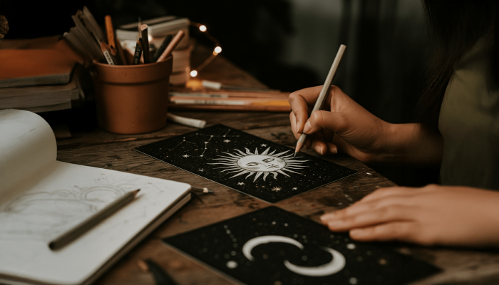 person finishing the last parts of a custom tarot card