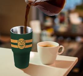 green tumbler with coffee pouring in