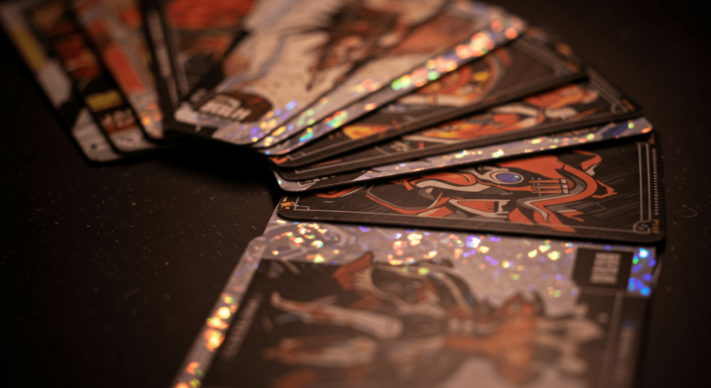 A fanned out set of holographic trading cards featuring colorful artwork and designs.