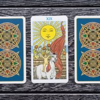 three custom printed tarot cards on a wooden bench
